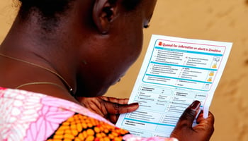 A woman looking at a medical brochure, symbolizing